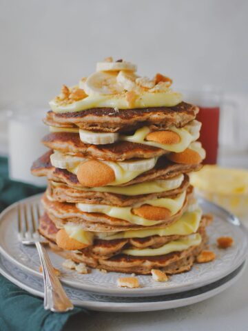 Banana Pudding Pancakes stacked up with pudding layered in between along with bananas and nilla wafers.