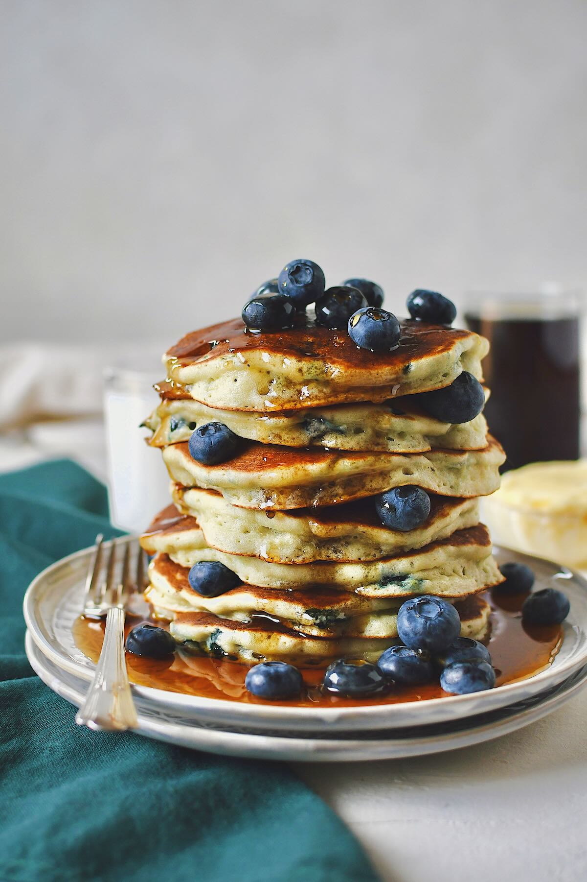 Blueberry Pancakes, stacked high, topped with more fresh blueberries and a generous pour of real maple syrup.