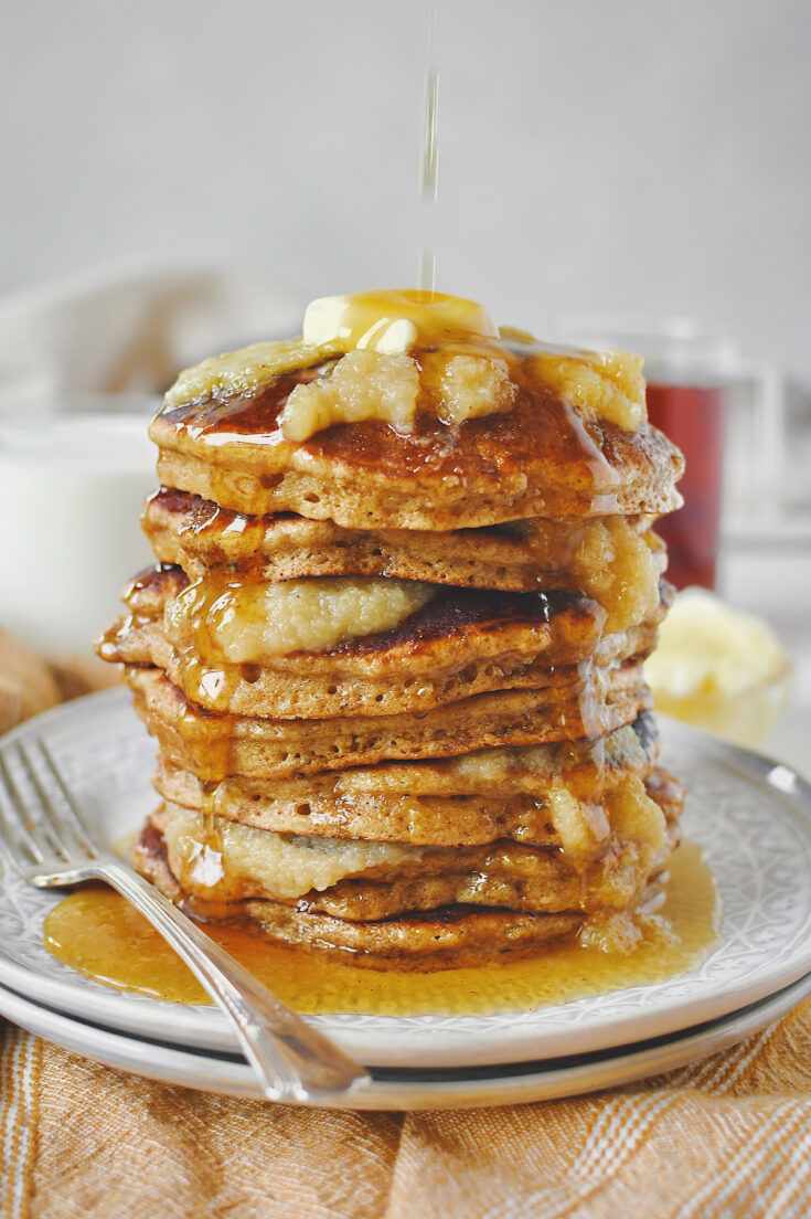 Applesauce Pancakes stacked high, with applesauce in between and on top. Topped with a pat of butter and lots of real maple syrup.