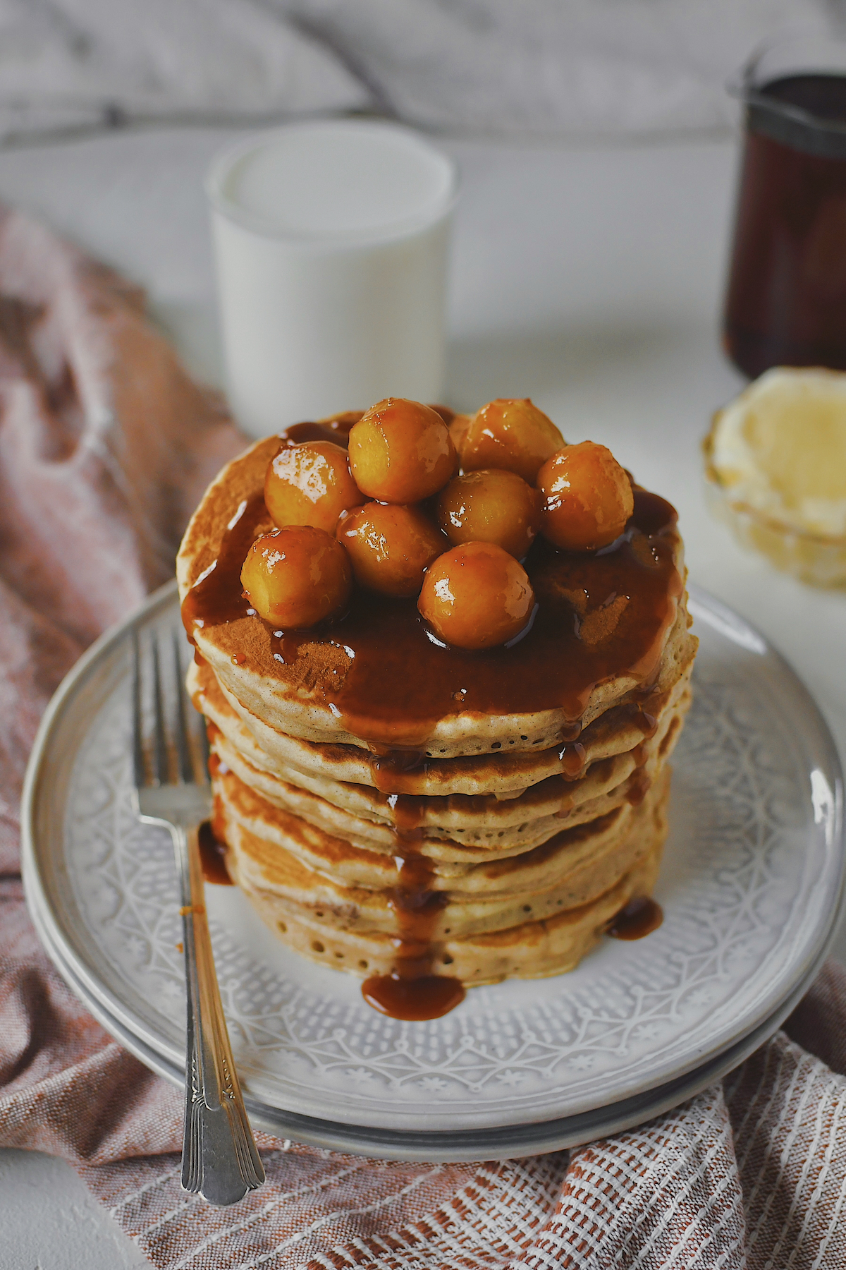 Caramel Apple Pancakes stacked high and topped with mini caramel apples and their sauce.
