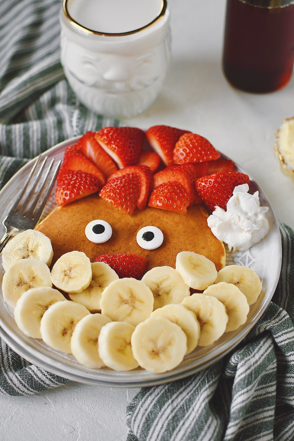 Santa pancakes on a plate with strawberries and bananas making his hat and beard.