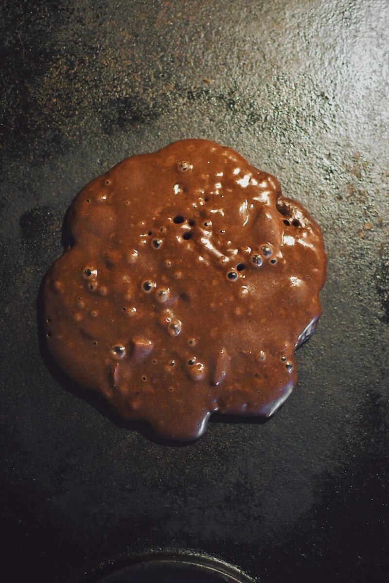 Pancake cooking on a hot griddle, notice the bubbles have begun to pop, this is an indicator that it is ready to flip.